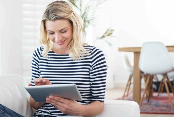 Mujer joven consultando información en una tableta digital.