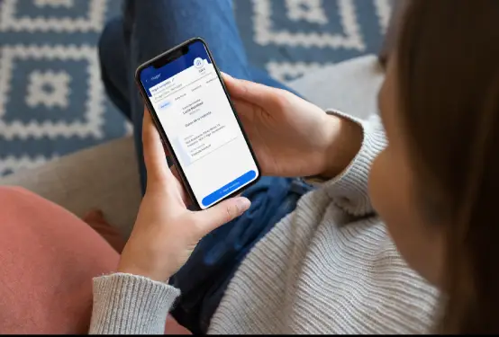 Mujer observa una aplicación en la pantalla de su teléfono móvil.