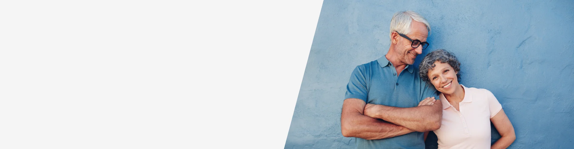 Dos personas adultas apoyadas sobre una pared azul, en actitud relajada, concepto de planificación financiera y productos unit linked para inversión