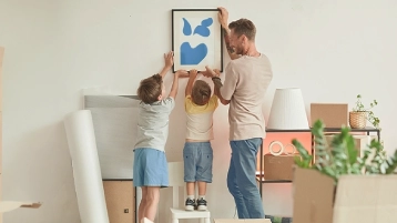Una familia desempaca cajas mientras se muda a su nuevo hogar, mostrando alegría y emoción.