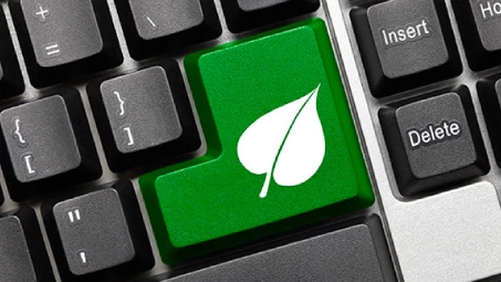 Tecla verde con icono de hoja en teclado, concepto de sostenibilidad y tecnología responsable