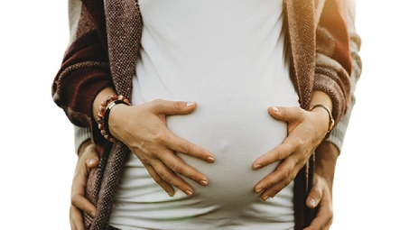 Manos sobre vientre de embarazo, concepto de protección familiar y seguros de vida