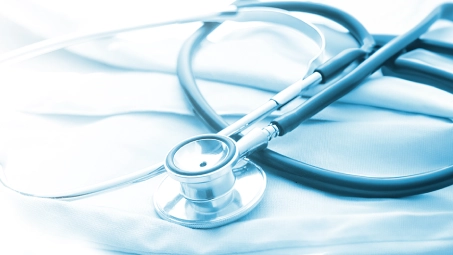 Estetoscopio sobre superficie blanca, símbolo de atención médica y seguros de salud