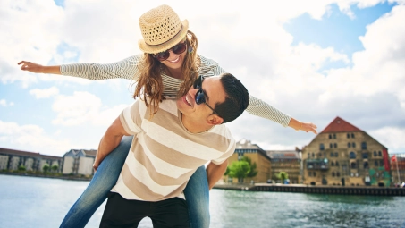 Pareja joven disfrutando al aire libre junto al agua, soluciones Santalucía para jóvenes