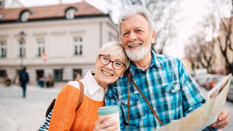 Pareja mayor consultando un mapa durante un viaje, soluciones Santalucía para jubilados