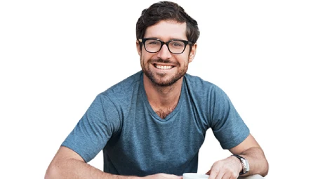 Persona con camiseta azul sosteniendo una taza blanca, en postura informal sobre fondo neutro