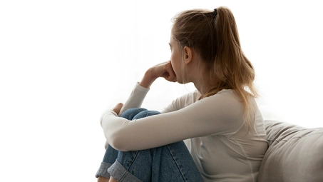 Persona sentada con ropa casual, mirando hacia un lado, en actitud reflexiva sobre decisiones importantes