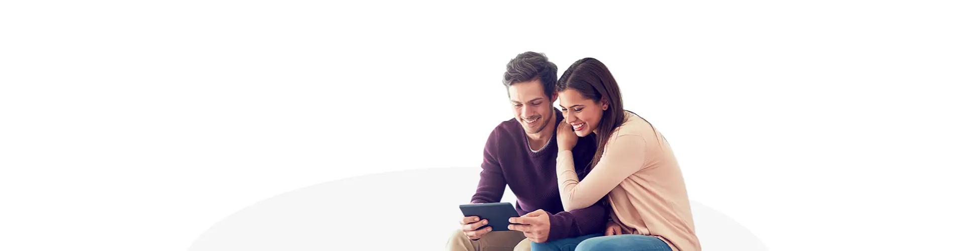 Dos personas jóvenes sentadas juntas consultando información en una tableta sobre un fondo blanco y gris minimalista
