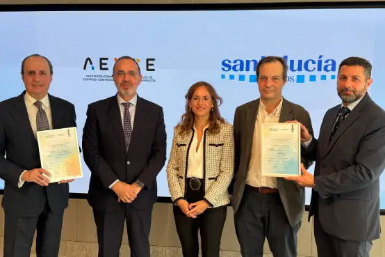 Representantes de SANTALUCÍA y AERCE posando con las certificaciones UNE 15896 e ISO 20400 en un acto oficial frente a los logotipos de ambas entidades.