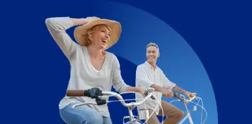 Dos personas montando en bicicleta sobre un fondo azul, una de ellas con sombrero y gesto dinámico mientras avanzan