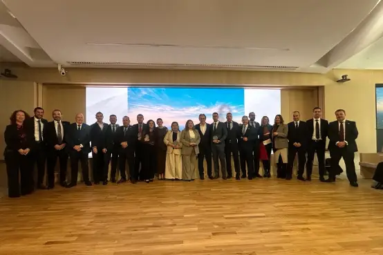 Grupo de personas en un escenario interior posando durante la convención anual del Canal de Agentes Exclusivos de Santalucía, con una pantalla panorámica al fondo y ambiente corporativo