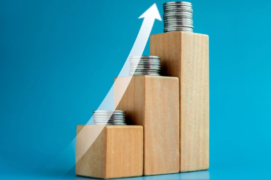 Gráfico conceptual de crecimiento financiero con pilas de monedas en ascenso y flecha al alza, vinculado a inversión y rentabilidad en productos de ahorro como Maxiplan Inversión Premium de SANTALUCÍA
