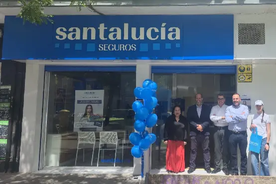 Fachada de una agencia de SANTALUCÍA en Vicálvaro con rótulo corporativo y equipo en la inauguración, dentro de la red de agentes exclusivos de la aseguradora.