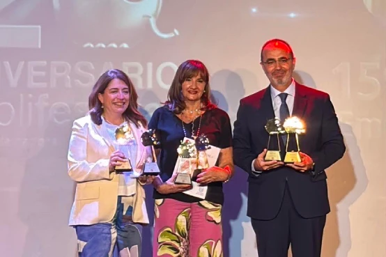 Imagen de tres personas en un escenario sosteniendo premios durante un acto de entrega, vinculada al reconocimiento del documental ‘La huella y el tiempo’ del Desafío SANTALUCÍA Seniors en Publifestival 2026.