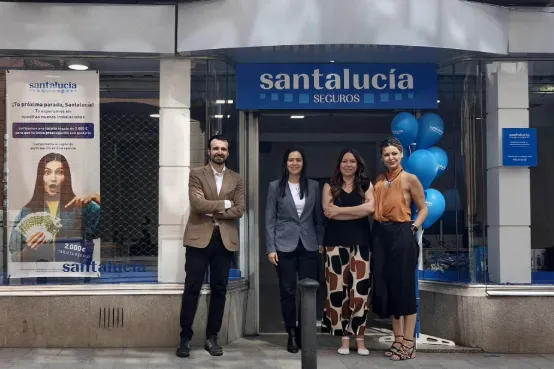 Fachada de una agencia de SANTALUCÍA en Astorga con rótulo corporativo y cuatro personas frente a la oficina durante su inauguración, dentro de la red de agentes exclusivos.